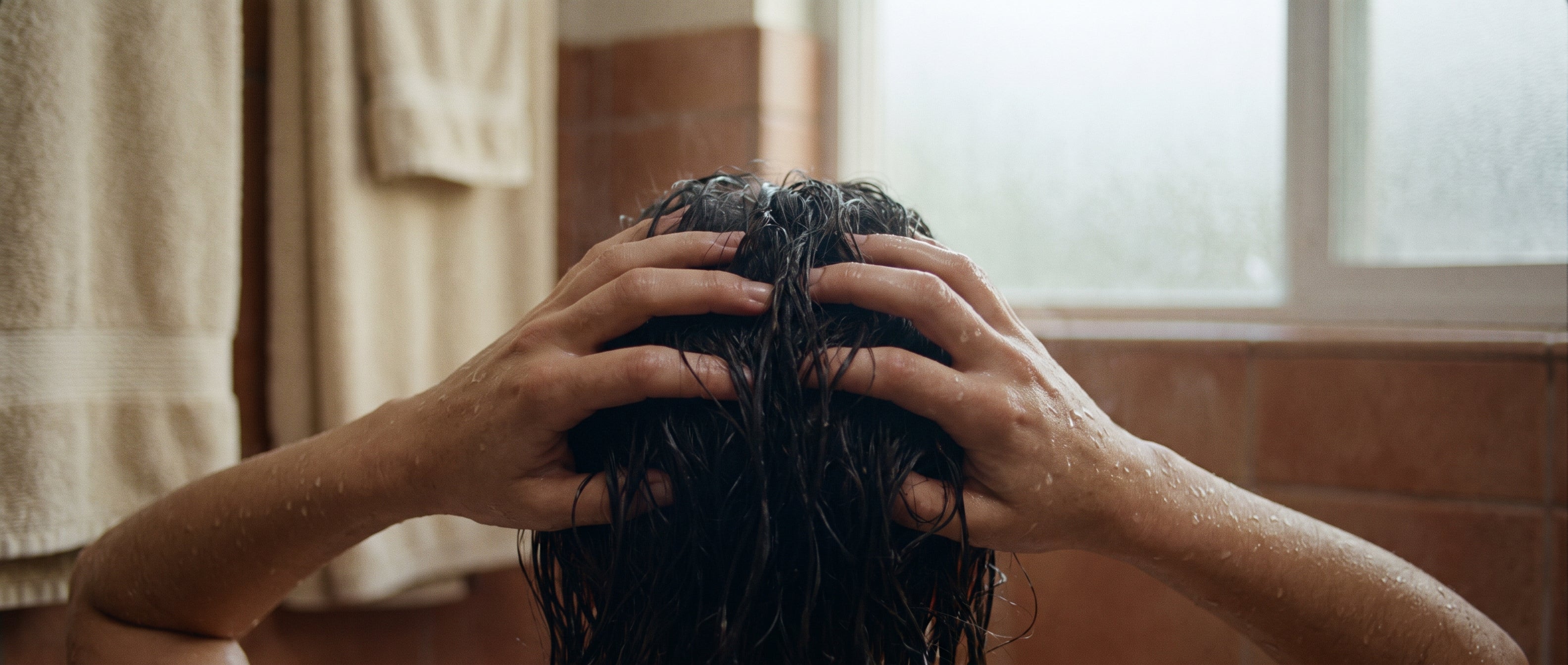 Handen die de hoofdhuid masseren tijdens het wassen
